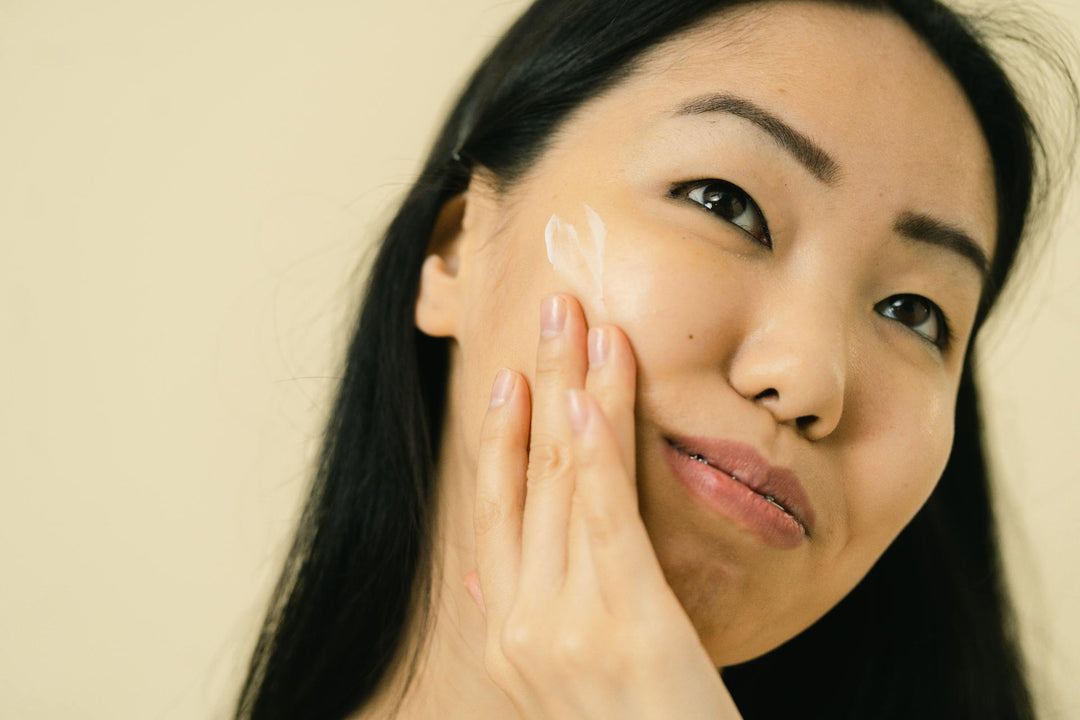 Woman applying a Korean moisturizer for dry skin on her face