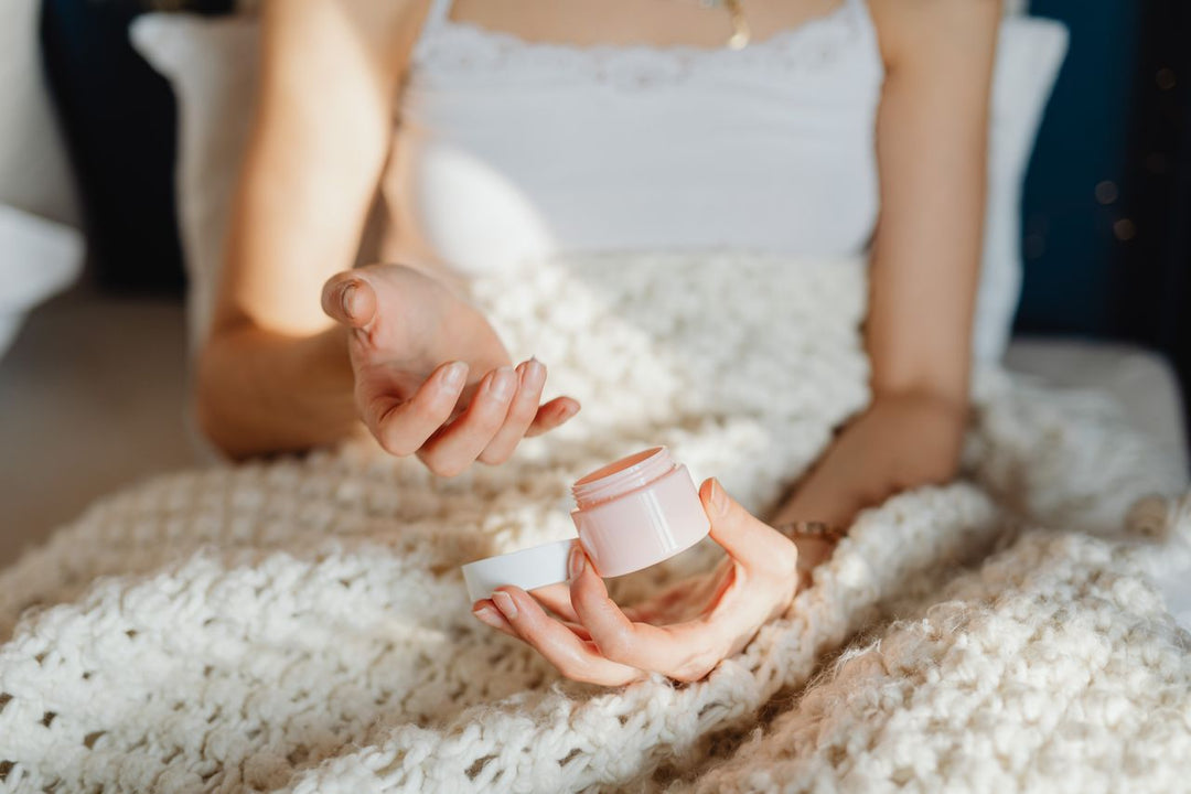 Person applying moisturizer from jar as part of their fall skincare routine