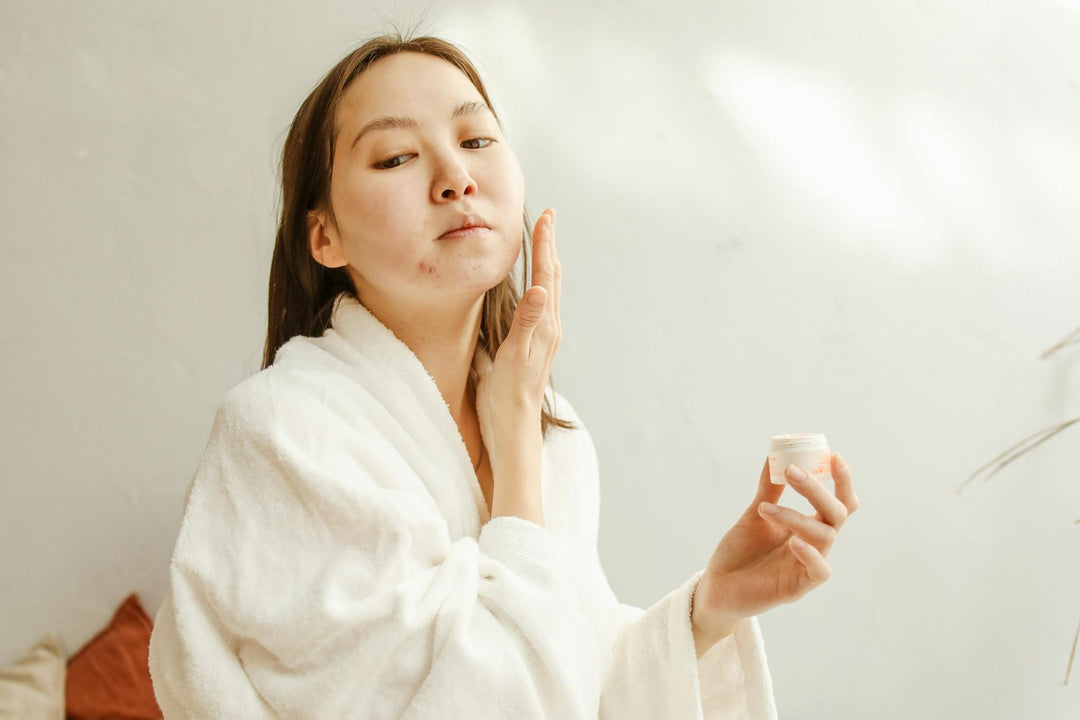 Woman in white bathrobe doing her winter skincare routine